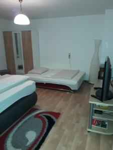 a bedroom with a bed and a flat screen tv at Ferienwohnung Grimmer in Weil am Rhein