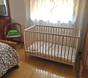 ein Kinderbett in einem Zimmer mit Fenster in der Unterkunft Casa de Barreiros in Braga + 50 Fotos