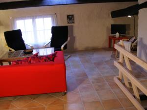 a living room with a red couch and a table at Feriehuset i Provence, VAR in Châteaudouble