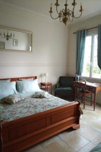 a bedroom with a bed and a chair and a window at La Roche Bellevue in Luynes