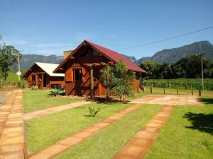 a house in a field with mountains in the background at Chalés Alvorada in Praia Grande