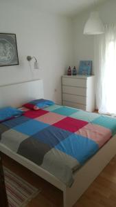 a bedroom with a bed with a colorful comforter at Apartmani Darko in Kornić
