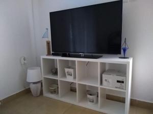 a tv on a white stand with a television on it at Apartmani Darko in Kornić