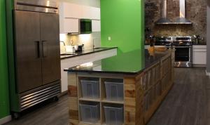 a large kitchen with green walls and a large island at Apple Hostels of Philadelphia in Philadelphia