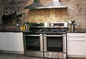 a kitchen with stainless steel appliances and a brick wall at Apple Hostels of Philadelphia in Philadelphia