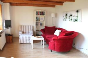 una sala de estar con 2 sillas rojas y una mesa. en Leuchtturm, en Fehmarn