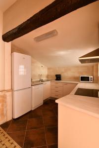 una cucina con elettrodomestici bianchi e frigorifero bianco di EVA & TRAVEL - El Cor del Montsant a Ulldemolins