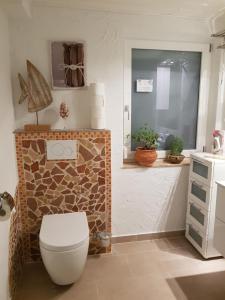 łazienka z toaletą i kamienną ścianą w obiekcie MinSion 38 w mieście Altdorf
