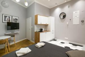 a room with a bed and a table and a kitchen at Welcome Apartments - Old Town in Krakow