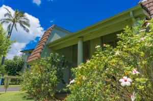 a green house with flowers in front of it at Puamana 4D Golf Courses Condo in Princeville