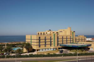 a large building with the ocean in the background at Hotel Solverde Spa and Wellness Center in Vila Nova de Gaia