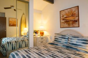 1 dormitorio con 2 camas y espejo en Banyan Harbor K132 At Kalapaki Beach Condo, en Lihue