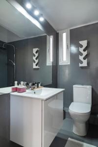 a bathroom with a white toilet and a sink at Plaka Heart in Athens