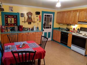 a kitchen with a table with a red table cloth at Gower Manor Historic Bed & Breakfast in St. John's