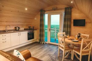 a kitchen and dining room with a table and a balcony at Braeside Retreats in Thurso