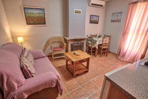 sala de estar con sofá y mesa en Apartamentos Rurales El Solitario en Baños de Montemayor