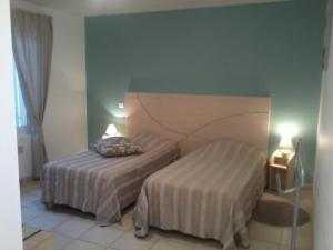 a hotel room with two beds and two lamps at Au Coeur Des Landes in Gaillères