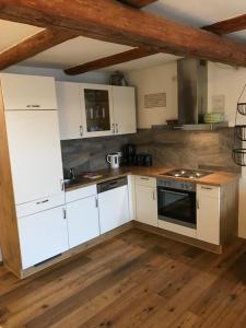 a kitchen with white cabinets and a stove at Gestüt Tiefenhof in Nittenau