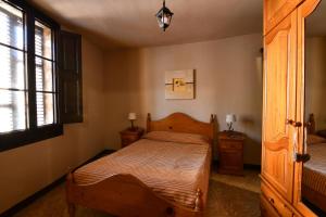 a bedroom with a wooden bed and two night stands at EVA & TRAVEL - El Cor del Montsant in Ulldemolins