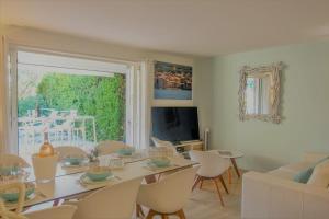 sala de estar con mesa, sillas y TV en Maison Centre village St Tropez Avenue Foch, en Saint-Tropez