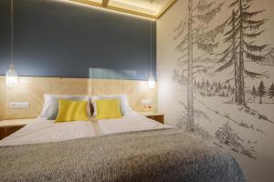 una camera da letto con un grande letto con cuscini gialli di Biała izba Apartamenty a Szaflary