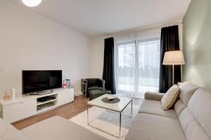 a living room with a couch and a tv at Apartment TriApart Big Blue in Gdańsk