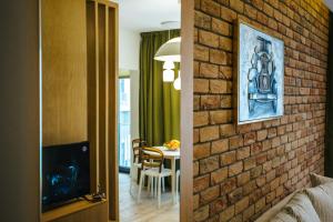 a room with a brick wall and a dining room at Briana Luxury Studio in Cluj-Napoca