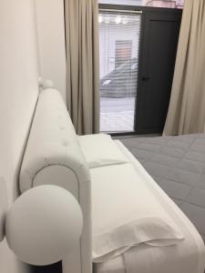 a white bed in a room with a window at Paolino Exclusive Rooms in Pachino