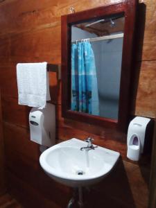 La salle de bains est pourvue d'un lavabo et d'un miroir. dans l'établissement Casa Maya, à Lívingston