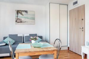 a dining room with a table and a couch at Apartament the Sun in Rewal +13 photos