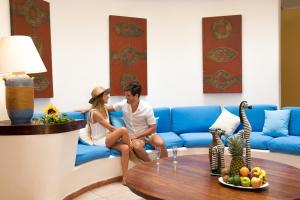 a man and a woman sitting on a blue couch at Hotel Riviera Caribe Maya in Playa del Carmen +28 photos