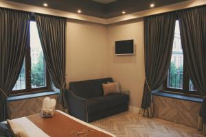 a room with a couch and a chair and windows at Hotel Roma Vaticano in Rome