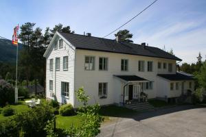 una casa blanca con techo negro en Furulund Pensjonat en Ron