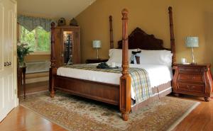 a bedroom with a canopy bed and a rug at Heartstone Inn in Eureka Springs