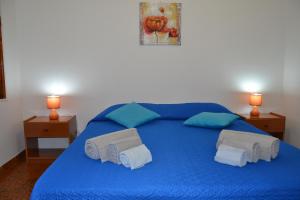 a blue bed with blue sheets and towels on it at Confortevole appartamento a pochi passi dal mare in Cala Gonone