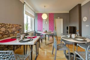uma sala de jantar com mesas e cadeiras e uma parede de pedra em Pension Vila Hana em Loket