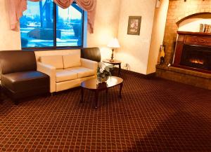 a living room with a couch and a table and a fireplace at Super 8 by Wyndham Woodstock in Woodstock