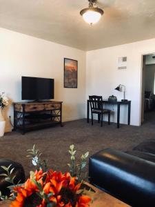 uma sala de estar com uma televisão de ecrã plano e uma mesa em Cedar Canyon Condos em Blanding