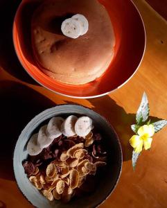 two plates of food with bananas and a bowl ofecake at Lazy Lizard Hostel in Siquijor