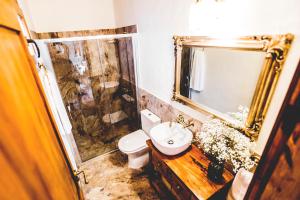a bathroom with a toilet and a sink and a mirror at La Casita de Papel in Valle Gran Rey