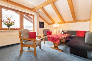 a living room with a table and a couch at "Haus Alpenblick" - Annehmlichkeiten von 4-Sterne Familien-und Wellnesshotel Viktoria können mitbenutzt werden in Oberstdorf