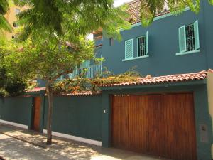 un edificio azul con dos puertas de garaje y un árbol en La Casona Azul en Lima