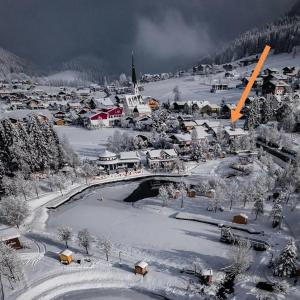 eine kleine Stadt voller Schnee mit einer Brücke in der Unterkunft Appartements Haus Bergland in Sankt Martin am Tennengebirge