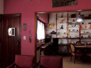 a dining room with a table and a pink wall at Ezenahí de la Cruz del Mar in Mar del Plata