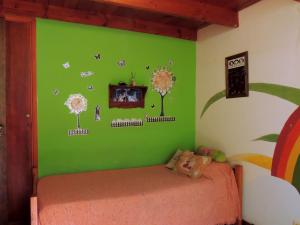a bedroom with a green wall with trees and butterflies at Ezenahí de la Cruz del Mar in Mar del Plata