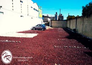 a car parked in a parking lot with red gravel at Hotel Rio in Xalapa