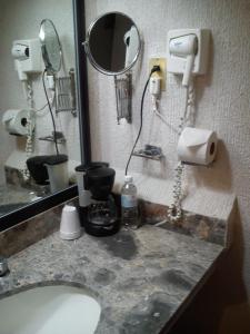 a bathroom with a sink with a mirror and a phone at Paraíso Express in Torreón