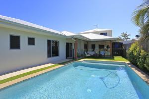 a swimming pool in front of a house at 12th Tee BnB in Bargara