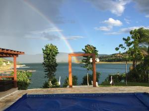 a rainbow over a pool with a view of the ocean at Nosso Recanto Pérola in Capitólio