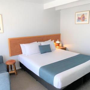 1 dormitorio con 1 cama grande y 1 silla en Collingwood Park Motel en Collingwood